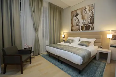 a hotel room with a bed and a chair at Zepter Hotel Belgrade, member of Zepter Hotels in Belgrade
