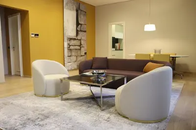 a living room with a couch and two white chairs at Zepter Hotel Belgrade, member of Zepter Hotels in Belgrade