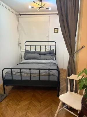 a bedroom with a bed with a black bed frame at Apartments Sat in Belgrade