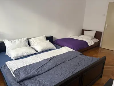 two beds sitting next to each other in a room at Apartments Sat in Belgrade