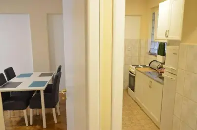 a small kitchen with a table and a table and chairs at Apartments Sat in Belgrade