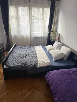 a large bed in a bedroom with a window at Apartments Sat in Belgrade