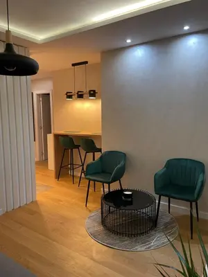 a living room with green chairs and a table at Apartments Jedro in Belgrade