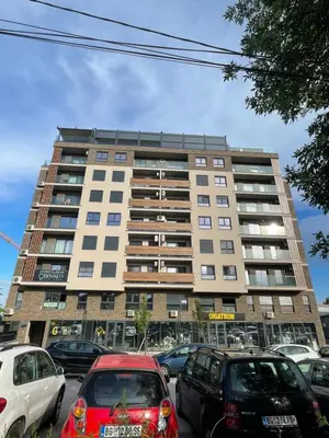 a tall building with cars parked in front of it at Apartments Jedro in Belgrade