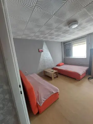 a room with two beds and a ceiling with at apartman Milica in Ruma