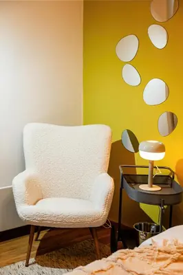a room with a chair and a table with a lamp at Grand Gallery with Cinema & Balcony Old Town in Belgrade