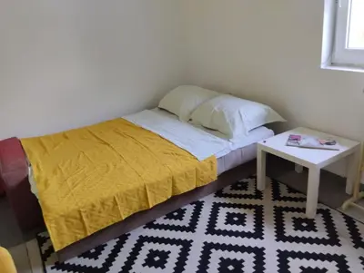 a bed with a yellow blanket and a table at Villa Salter in Belgrade