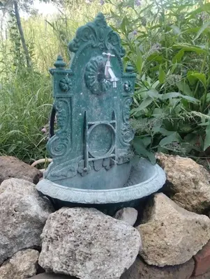 a green clock sitting on some rocks at Villa Salter in Belgrade