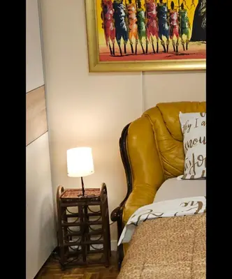a yellow leather chair sitting next to a table with a lamp at Narnia in Belgrade