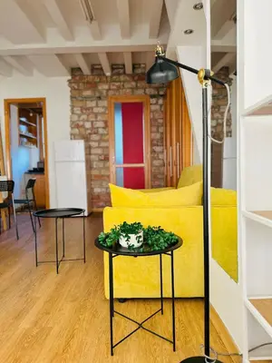 a living room with a yellow couch and a table at Belgrade Central 532- Obilicev Venac in Belgrade