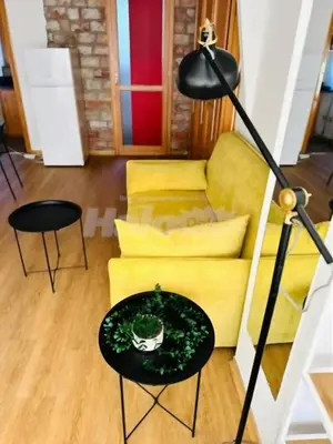 a living room with a yellow couch and a table at Belgrade Central 532- Obilicev Venac in Belgrade