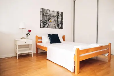 a bedroom with a large white bed and a nightstand at Crown Central three bedroom Apartment in Belgrade