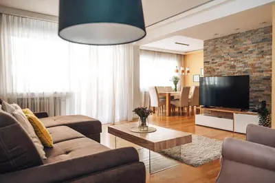 a living room with a couch and a flat screen tv at Crown Central three bedroom Apartment in Belgrade