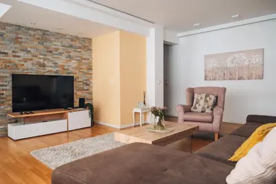 a living room with a couch and a tv at Crown Central three bedroom Apartment in Belgrade