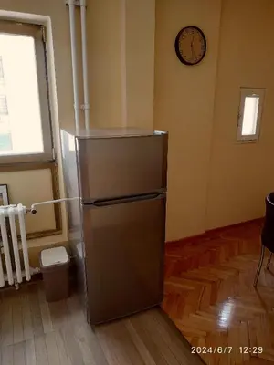 a refrigerator in a room with a clock on the wall at Genex Gate in Belgrade