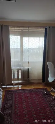a living room with a large window and a rug at Genex Gate in Belgrade