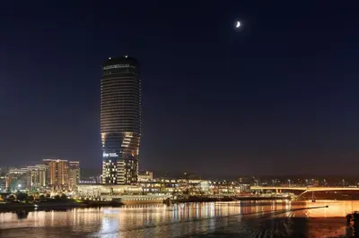 a tall building at night with a city at The St. Regis Belgrade in Belgrade