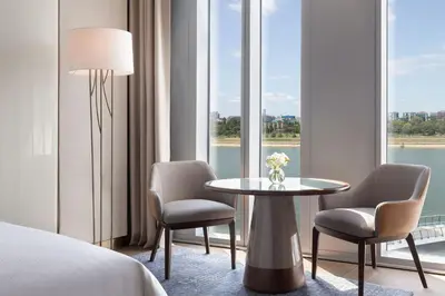 a hotel room with a table and chairs and windows at The St. Regis Belgrade in Belgrade
