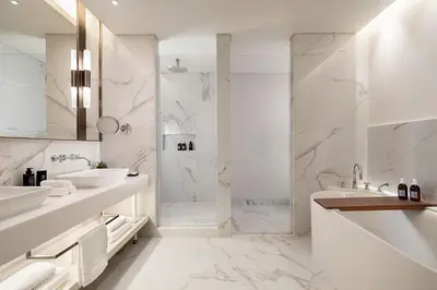 a white bathroom with two sinks and a shower at The St. Regis Belgrade in Belgrade