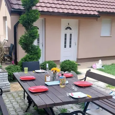 a wooden table with red napkins on it in front of a house at Sweet memories 2 in Žarkovo