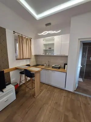 a kitchen with white cabinets and a wooden table at Sweet memories 2 in Žarkovo