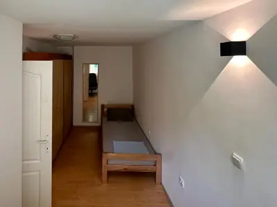 a room with a bed in the corner of a room at Apartment GreenTerrace next to TC BIG FASHION Mall in Karaburma