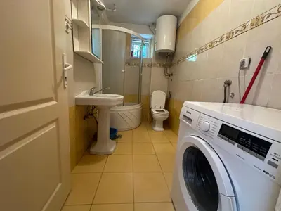 a washing machine in a bathroom with a toilet at Apartment GreenTerrace next to TC BIG FASHION Mall in Karaburma