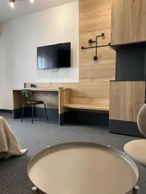 a room with a desk and a tv on a wall at Sremsky inn in Stara Pazova