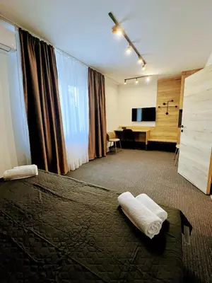 a hotel room with a bed and a desk with a television at Sremsky inn in Stara Pazova