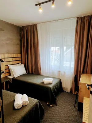a hotel room with two beds and a window at Sremsky inn in Stara Pazova