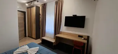 a bedroom with a bed and a television on a wall at Sremsky inn in Stara Pazova