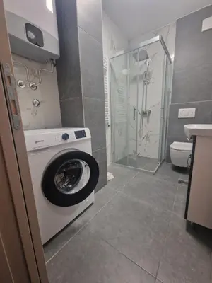 a bathroom with a washing machine and a shower at Andrej Lux in Jajinci