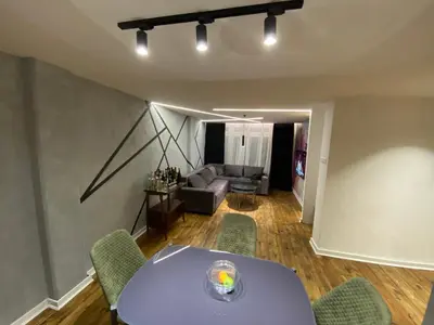 a living room with a table and chairs and a couch at 87m2 Blok24 Arena Business in Belgrade