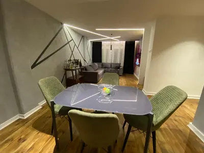 a dining room with a table and chairs and a couch at 87m2 Blok24 Arena Business in Belgrade