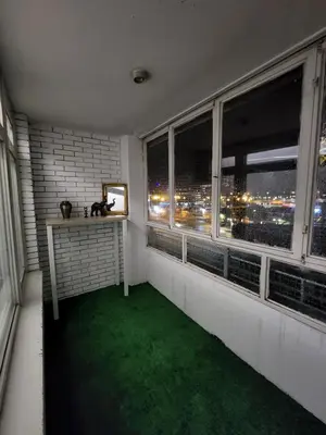 a room with a green floor and windows with a view at 87m2 Blok24 Arena Business in Belgrade