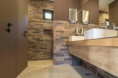 a bathroom with two sinks and a brick wall at Espacio Resort - Pool & Spa in Novi Vladimirovac