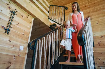 a woman and child on a staircase in a cabin at Espacio Resort - Pool & Spa in Novi Vladimirovac