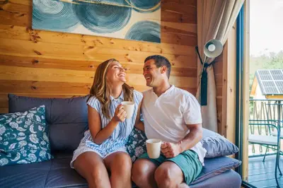 a man and woman sitting on a couch drinking coffee at Espacio Resort - Pool & Spa in Novi Vladimirovac
