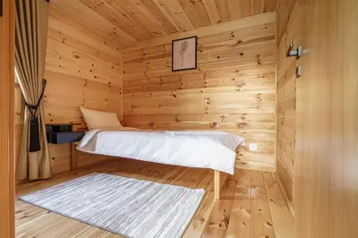 a room with a bed in a wooden cabin at Espacio Resort - Pool & Spa in Novi Vladimirovac