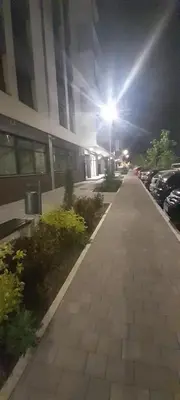 a sidewalk in front of a building at night at Elegance in Zemun