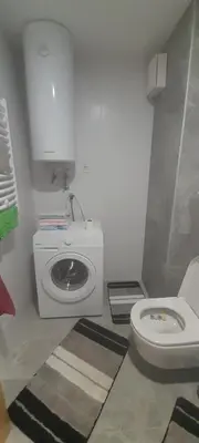 a bathroom with a washing machine and a toilet at Elegance in Zemun