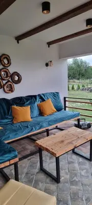 a living room with a blue couch and a wooden table at NaVisu avlija in Kruševica