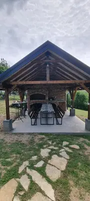 a pavilion with a table and benches in a park at NaVisu avlija in Kruševica