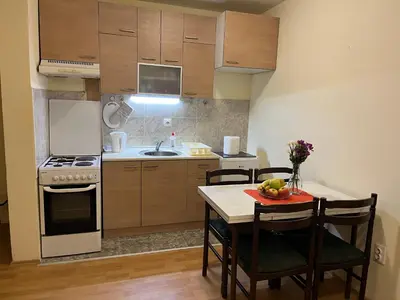 a kitchen with a table and chairs and a kitchen with a stove at Peaceful Apartment Simovic in Belgrade