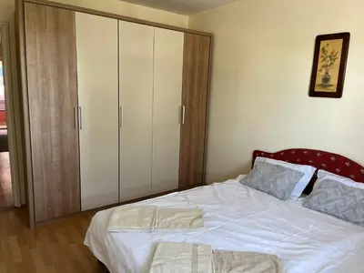 a bedroom with a bed with white sheets and a cabinet at Peaceful Apartment Simovic in Belgrade