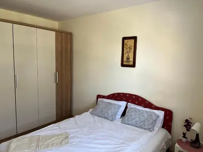 a bedroom with a white bed with a red headboard at Peaceful Apartment Simovic in Belgrade