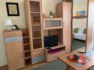 a living room with a large wooden cabinet with a television at Peaceful Apartment Simovic in Belgrade