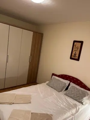 a bedroom with a bed with white sheets at Peaceful Apartment Simovic in Belgrade