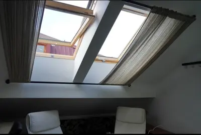 two windows in a room with two white chairs at Soffito studio in Belgrade