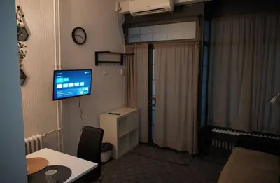 a room with a television and a desk with a table at Soffito studio in Belgrade